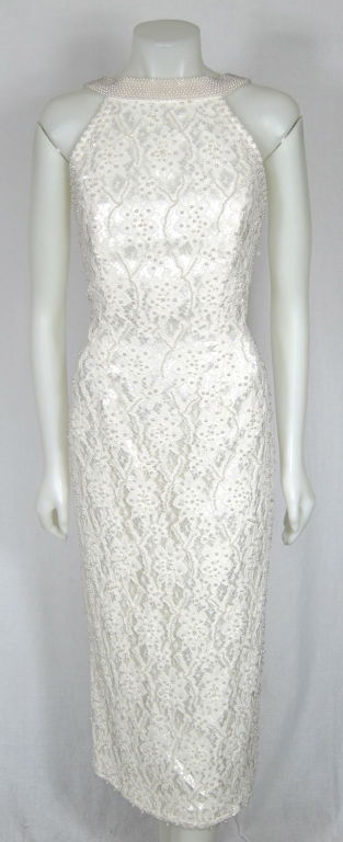 Featured is a figure hugging white lace dress by Oleg Cassini, also known as 