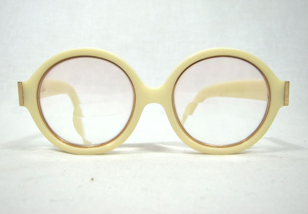 Featured is a glamorous pair of vintage eyeglasses by Christian Dior from the later 1960s. The sturdy frames are pale ivory color, accented with subtle gold around the lenses and at the temples. Gorgeous logo detail at the arms. Currently fitted