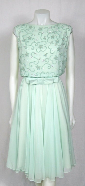 This is a beautiful dress made of sea foam chiffon. The bodice is is beautifully beaded with beads and iridescent sequins. There is a bow at the natural waist,fully lined with a metal zipper. Soft and elegant dress for cocktail party or great for