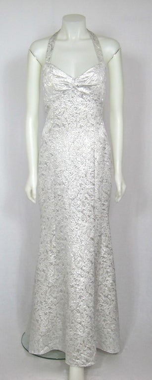 Fabulous formal long dress. It is a soft metallic textured fabric and  is a halter style with a cage low cut back with lovely fish tail hem. The bust has a slight ruching and the dress is lined. This dress is perfect for a wedding and/or formal