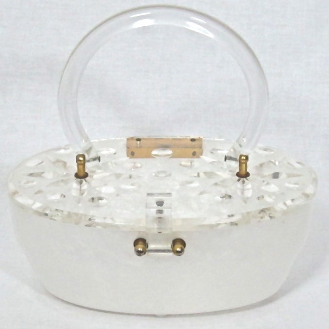 Featured is an elegant vintage purse from the 1950s. Milky white marbelized Lucite with a carved lid. Strong clasp. Molded feet.

Height: 8.5