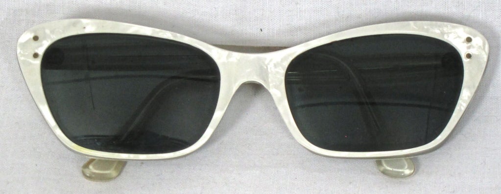 Featured is a vintage pair of sunglasses from France, circa the 1950s. Milky white marbled Lucite frames with dark lenses. By Sunguide.

Front width: 5.5
