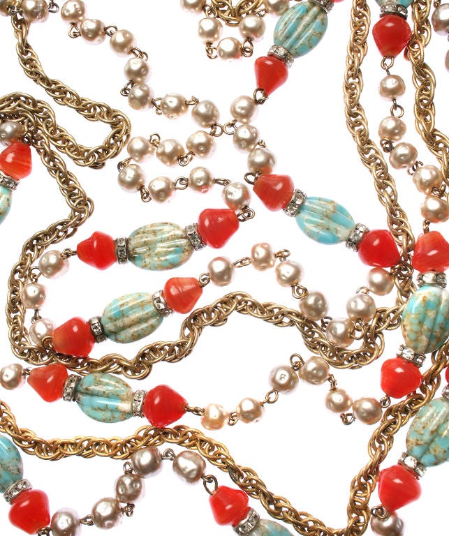 This is a gorgeous multi strand necklace. Gilt metal chains are accented by coral and tourquoise colored poured glass beads, rhinestone rondelles and faux pearls. <br />
*Measurements*<br />
The inner strand is 27 1/2