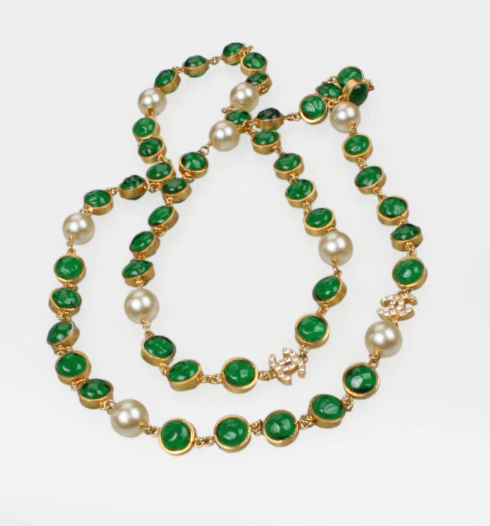 This is an unusual and beautiful Chanel Sautoir. The  rich green glass elements are poured glass (Maison Griopoix,) instead of the usual faceted crystals.The necklace accented with Chanel  Logo interlocking rhinestone CC's is 23