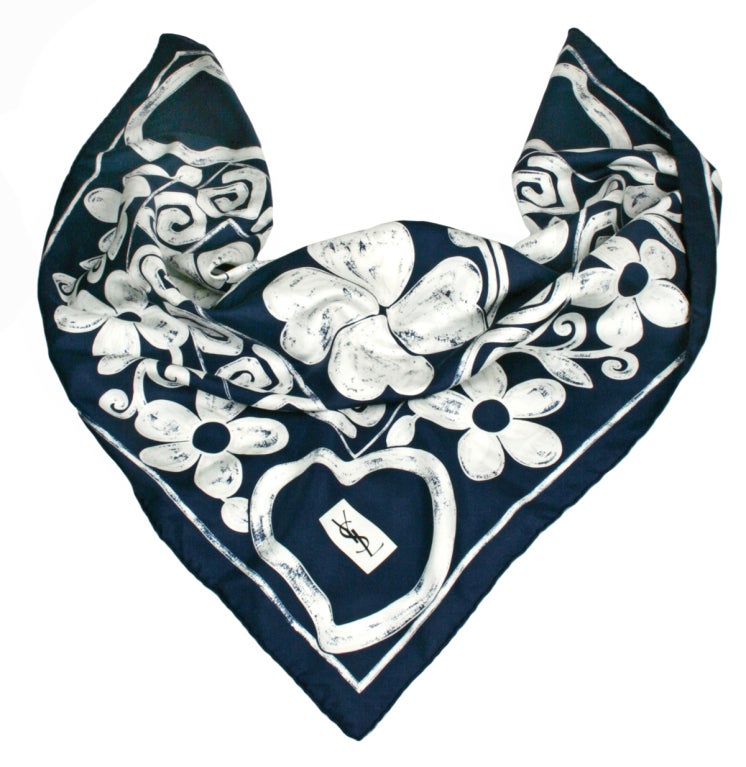 An elegant and appealing silk scarf with hearts and clover motifs by YSL. The Navy and White colors give a distinctly modern look. Made of 100% silk.