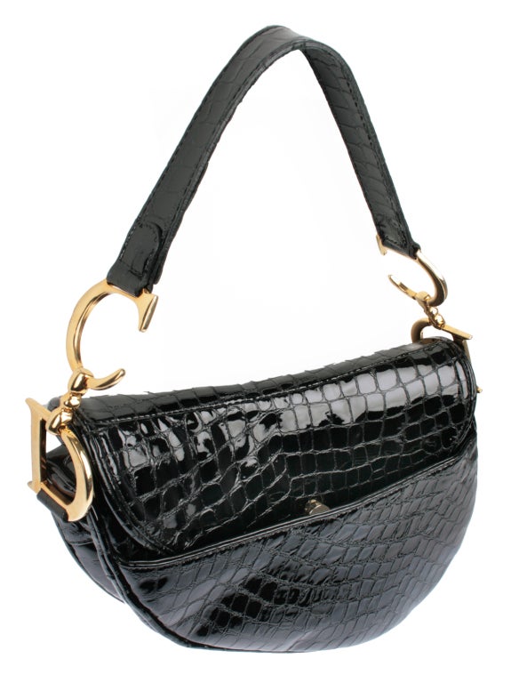 This Christian Diors Saddle bag is in a patent leather with a  reptile design.   Terrific style and a large interior with zippered comparment. The front fastens with a very secure velcro strap. The back pocket closes with a magnetic clasp. The