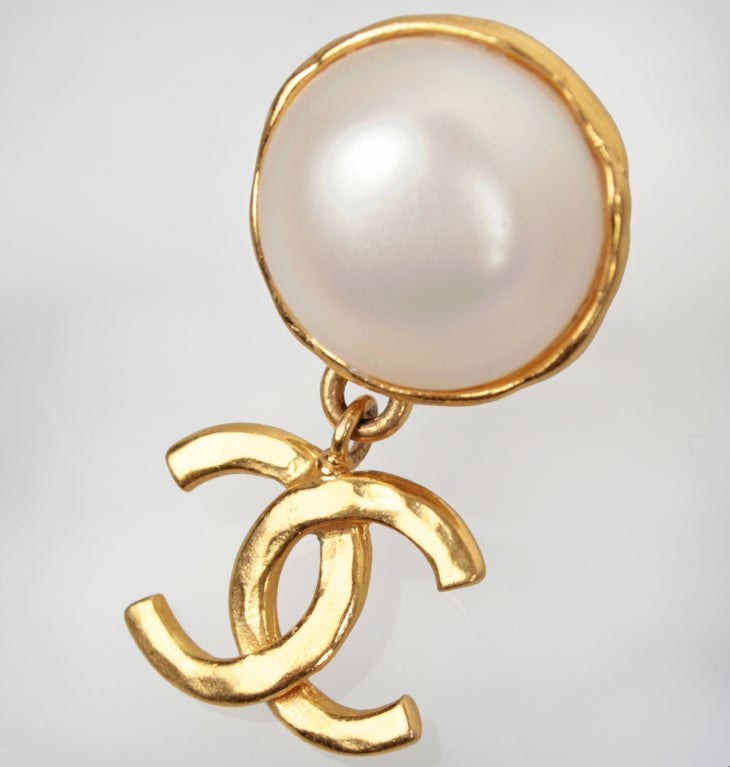 These are large fun faux pearl earrings with a hanging CHANEL Logo. Marked 93 P Spring collection.

Toal length is 1-3/4