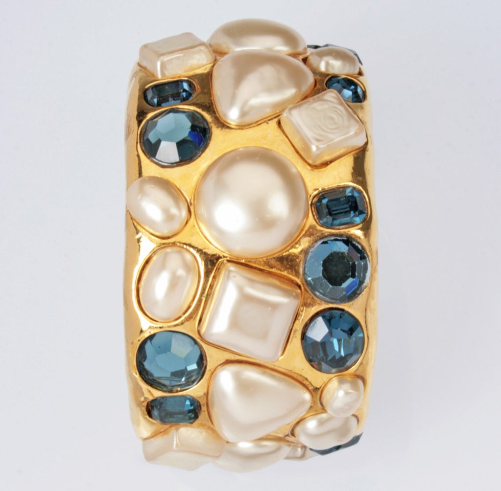 This is a stunning CHANEL  bracelet with blue faceted glass gems and faux pearls that are set into a cuff. Marked 2-6 for Season 26. The inside wrist opening is 2 3/8 