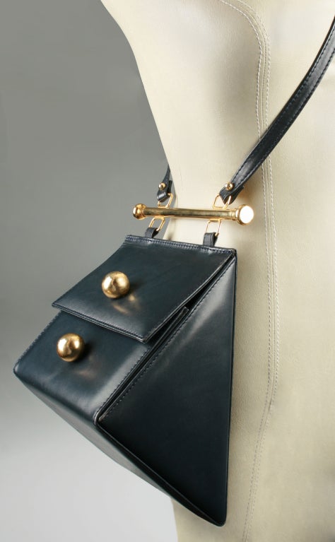 This is a very unique shaped shoulder bag highlighted with great hardware. Hanging vertically the top opens up and the front gusseted panel opens out to allow easy access. With a magnetic latch and an inside gusset pocket. Overall strap length is