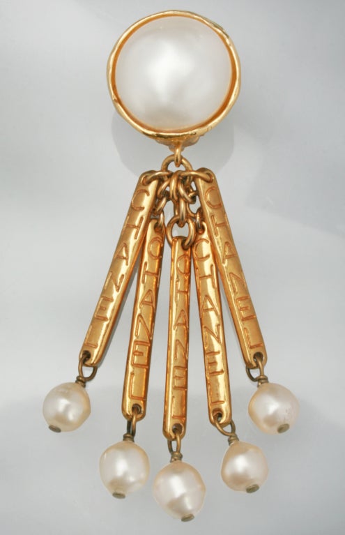 These are fun and great looking CHANEL earrings.  There are five movable gold toned dangles, each marked CHANEL and culminating in a pearl. The large 