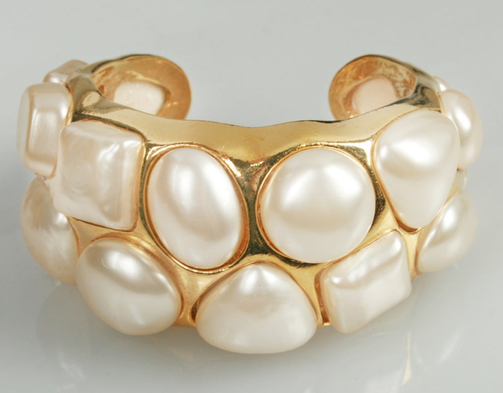 Chanel bracelet in gold tone with inset faux pearls, in varios shapes. The widest inside measurement is 2 " across. 
Marked on the back.....Chanel, Made in France,  Season 2-6.