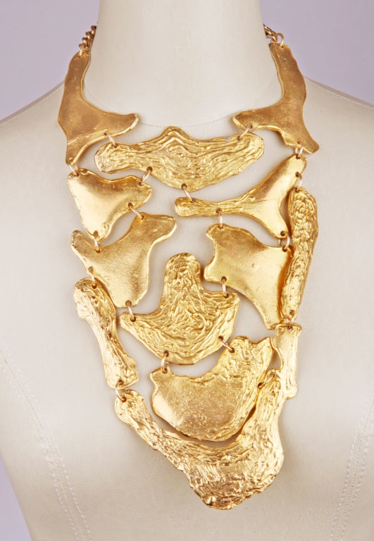 This is a great looking bib constructed of gold toned biomorphic elements with smooth and textured surfaces. The neck size is 13.25
