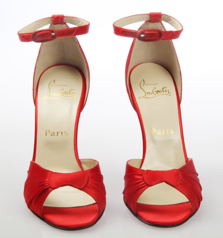 These are exquistely detailed Red Satin Shoes by Christian Louboutin. They come in their original box with shoe bag.