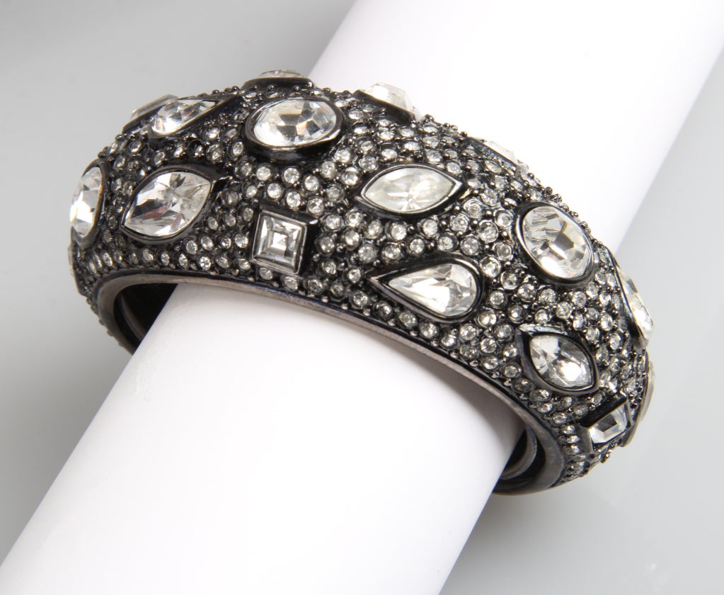 This is a chic bracelet encrusted with rhinestones in an interesting paisley like pattern. There are five different cuts of stones and it has an interior bracelet guard. 
The interior circumference is 5.75