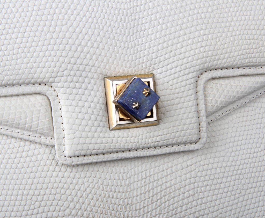 This is a vintage Gucci white lizard handbag made as a custom order for an urban socialite.
The clasp is a mounted piece of Lapis that turns to unlock.
When opened, the first padded flap lifts to an open a sleeve compartment. Also notice that