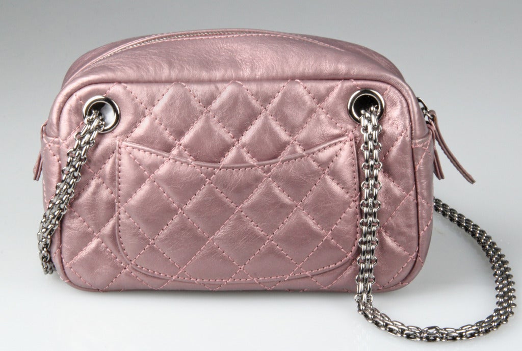 This CHANEL leather bag has a chain that threads through the interior of the bag and can be worn either as a shoulder or handbag. The strap will also store in the exterior pocket and allow you to use the bag as a clutch.

The inside has one side