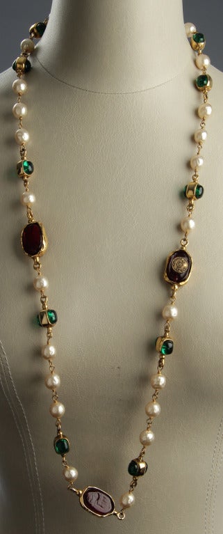 This is a beautiful CHANEL sautoir boasting rounded green cabochons and deep red poured glass elements.