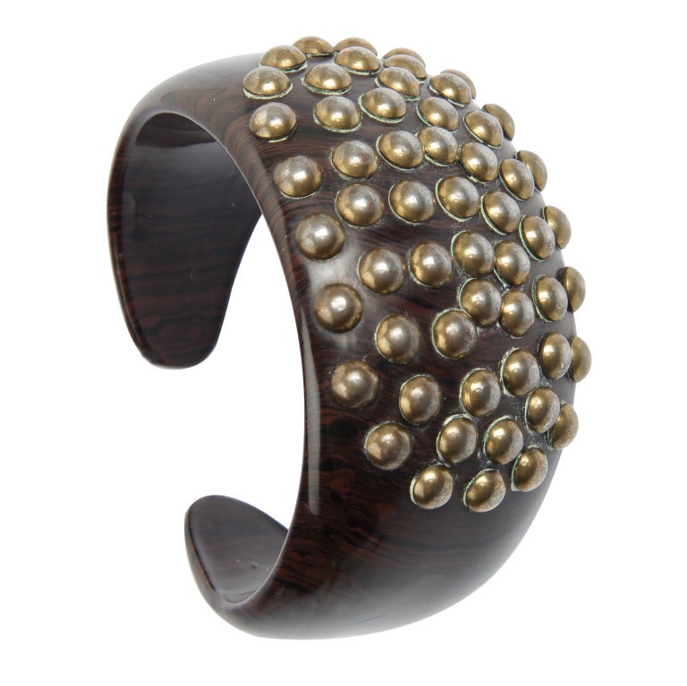 These are great looking and interesting cuffs.  Designed for YSL between 1987 and 1999, these are great for the smaller wrist. The material is wood studded with brass. The interior diameter is 6.25 inches with a .75 opening.