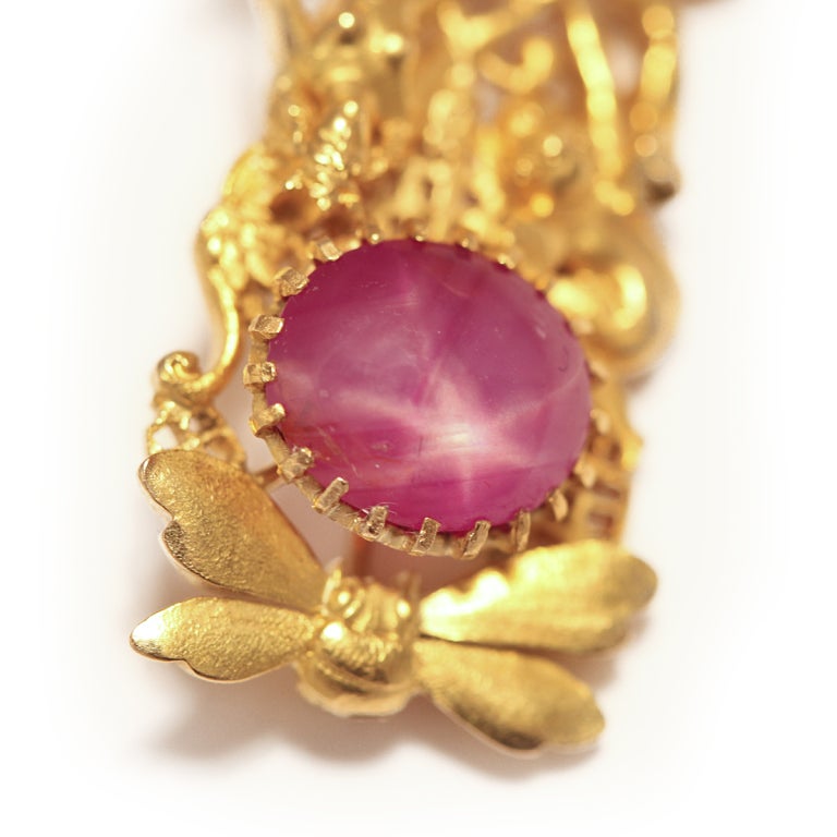 Titania reclines amidst a dragonfly and a wasp on a spiderweb while holding hands with winged Puck. The pin is sculpted in 18kt gold and adorned with an oval cabochon 5.84 ct star ruby and a natural pearl drop.

By Tiffany and Co.