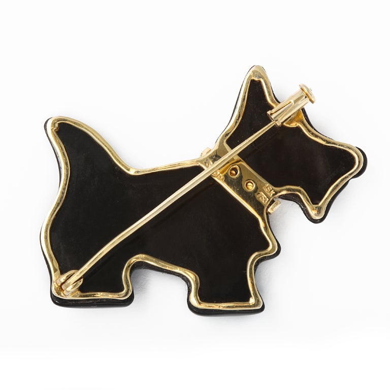 Black onyx Scottie dog pin with 18K gold eye, bow tie collar, and mount. Length: 1-3/4 inches