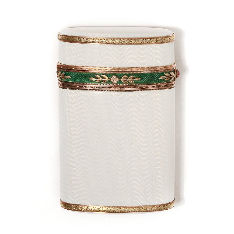 Fabergé engine-turned white enamel cigarette case with a green enamel border set with two-color gold rosettes and a ruby push piece. Chased gold borders, the top and bottom with laurel leaves, define the architecture of the case.
Workmaster, Henrik