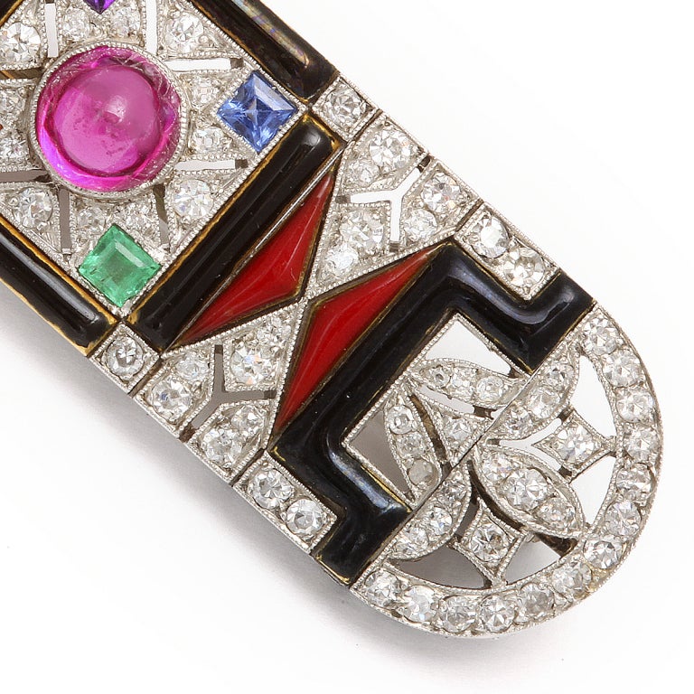 Egyptian Revival Art Deco Jeweled Brooch
Art Deco Egyptian Revival Jeweled Brooch.The diamond and black onyx brooch, set in platinum, the center embellished with a  cabochon-cut natural ruby with an emerald, sapphire, amethyst and citrine in each