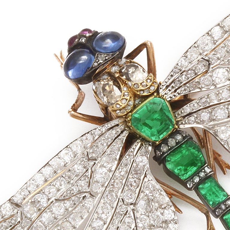 Emerald and diamond Dragonfly brooch, the wings in platinum set with diamonds, the body set with emeralds, and the eyes with two cabochon sapphires.