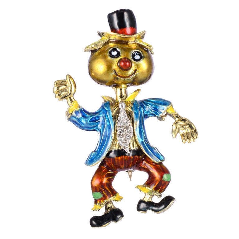 Multi-colored enamel and gem-set pair of  gold brooches. He is dressed as a scarecrow with a pumpkin-shaped head, hay for hair, hay coming out of his cuffs, and patches on his pants.