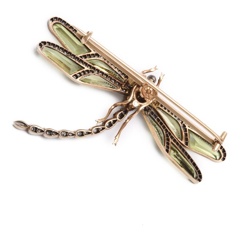 Pin in the form of a dragonfly featuring diamond body with peridot and diamond wings, en tremblent, set in silver and gold.