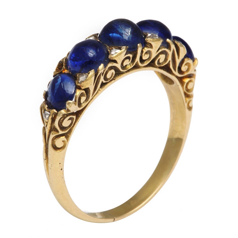 Gold ring featuring five cabochon sapphires set in an openwork mount.