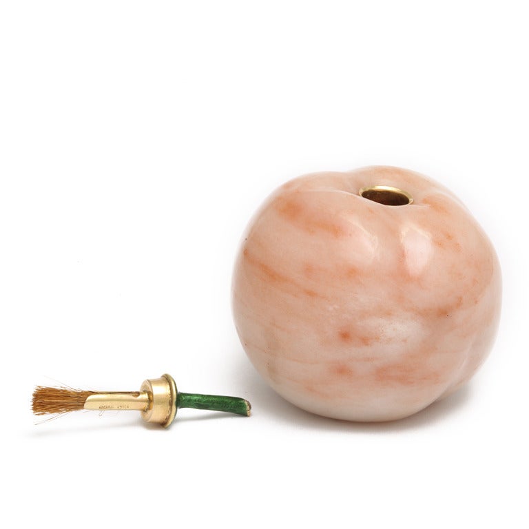 Gold-mounted aventurine quartz apple-form gum-pot, the enamelled stem with rose-cut diamond, and with interior brush fitting.

By Fabergé, workmaster E. Kollin
St. Petersburg, 1899-1901
Diameter: 2 inches

Provenance:
Dowager Empress Maria