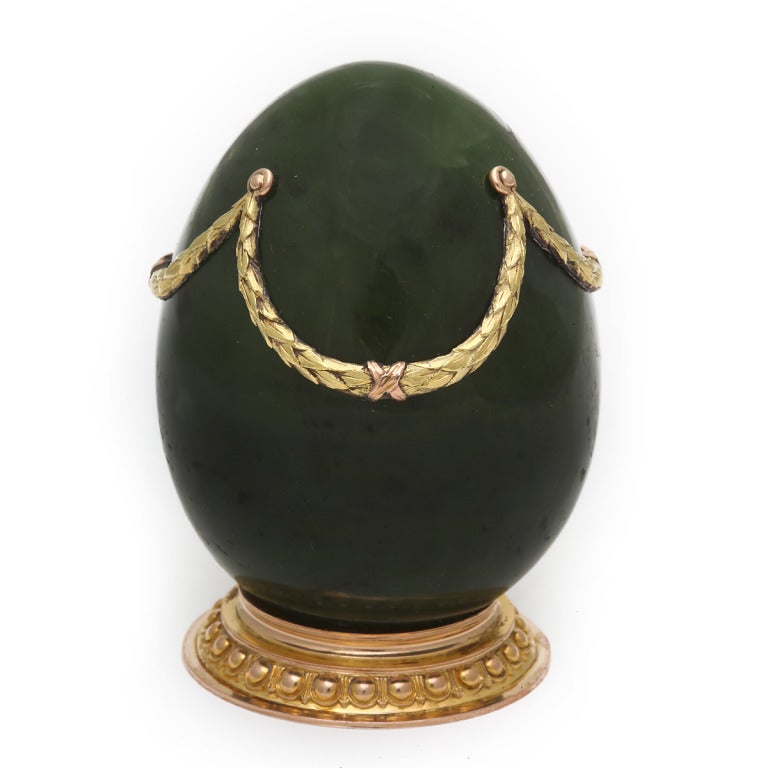 Nephrite egg-form photo frame. Decorated with gold bows and swags on a gold base.