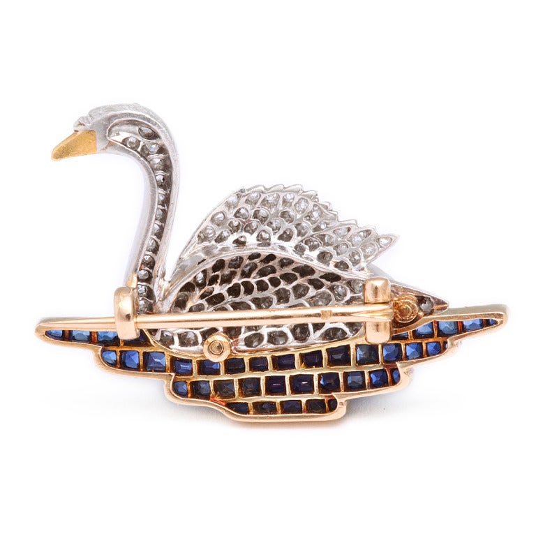 Pavé diamond swan brooch set in platinum and gold swimming on a pond of calibré cut sapphires. The French firm Hartz developed a reputation for jewelry designs featuring animals and mythological creatures. Swimming on a pond of sapphires, this swan