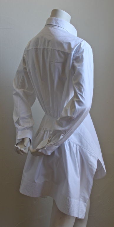 Crisp white shirt dress with slits at sides from Azzedine Alaia. Labeled a French size 38. Can be worn as a tunic or as a mini dress. Buttons up front. French cuffs. Measures approximately 34