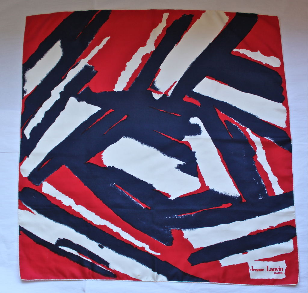 Vivid silk square scarf with hand rolled edging from Jeanne Lanvin dating to the 1970's. Colors are red, blue, white and black. 30