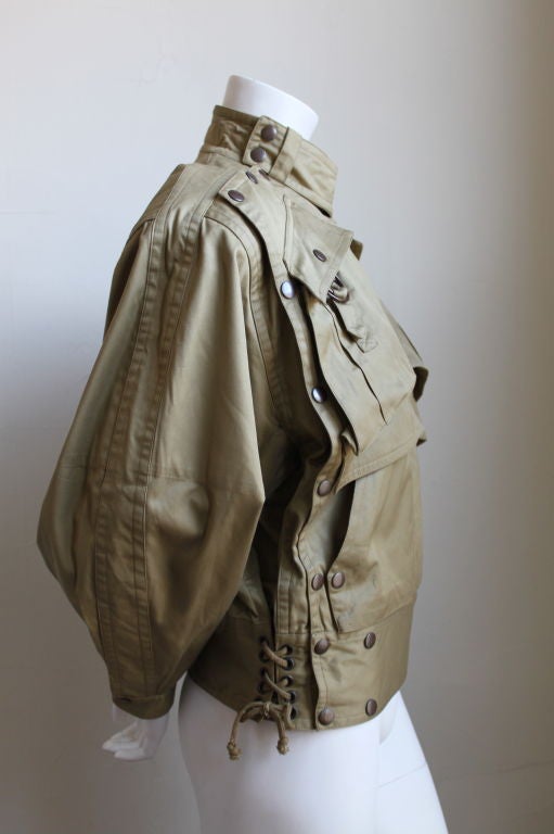 Very rare khaki cotton jacket with numerous snaps, pockets and side waist ties from Kansai Yamamoto dating to the 1980's. Best fits a size small or medium. Made in Japan. Very good condition.