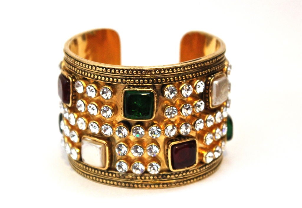 This stunning cuff is an amazing example of the work of Maison Gripoix for the house of Chanel dating to 1987 (season 23). Cuff measures approximately 2" wide, 6.5" in length and it has a 1" opening. This is a very heavy weight cuff.