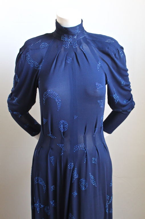 Very rare blue jersey dress with sparkling star and moon motif from Jean Muir dating to the 1970's. Dress has a very flattering cut. It is labeled a UK 8 which best fits a US 2-6. Zips up center back and secures at back of neck with four clear