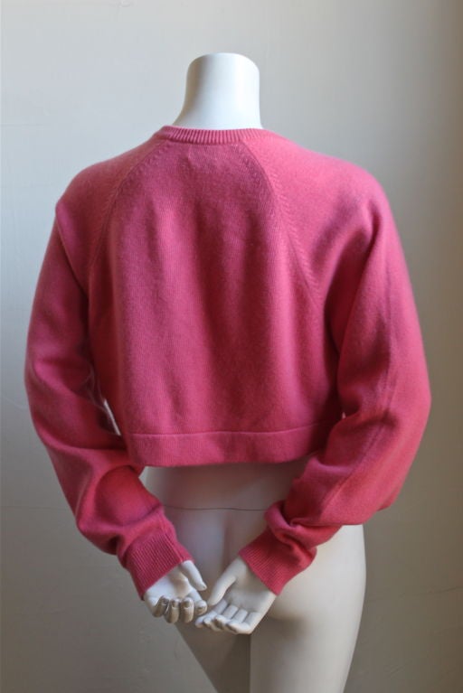 Vivid fuchsia cropped cashmere cardigan with large gilt buttons from Chanel dating to the 1980's. Cardigan is labeled a size small however, it fits a small or medium due to oversized cut. Bust measures 38