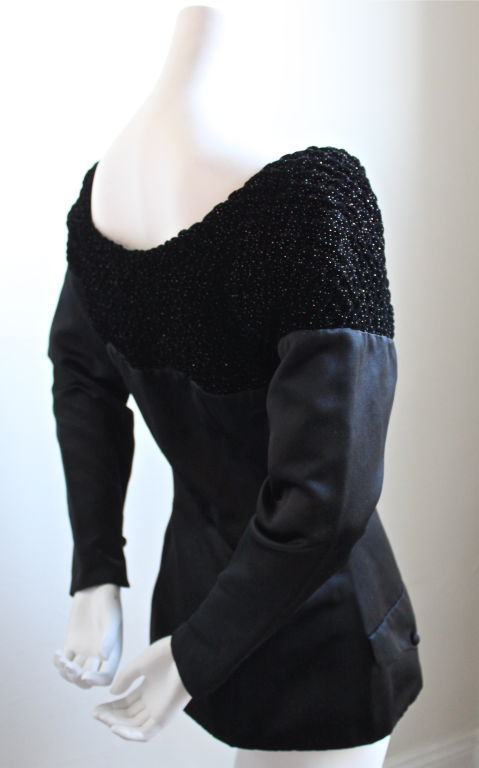 Jet black satin jacket with sparkly smocked velvet neckline from Lanvin dating to the 1980's. Fits a size 6 (with broad shoulders) or 8. Bust measures 36