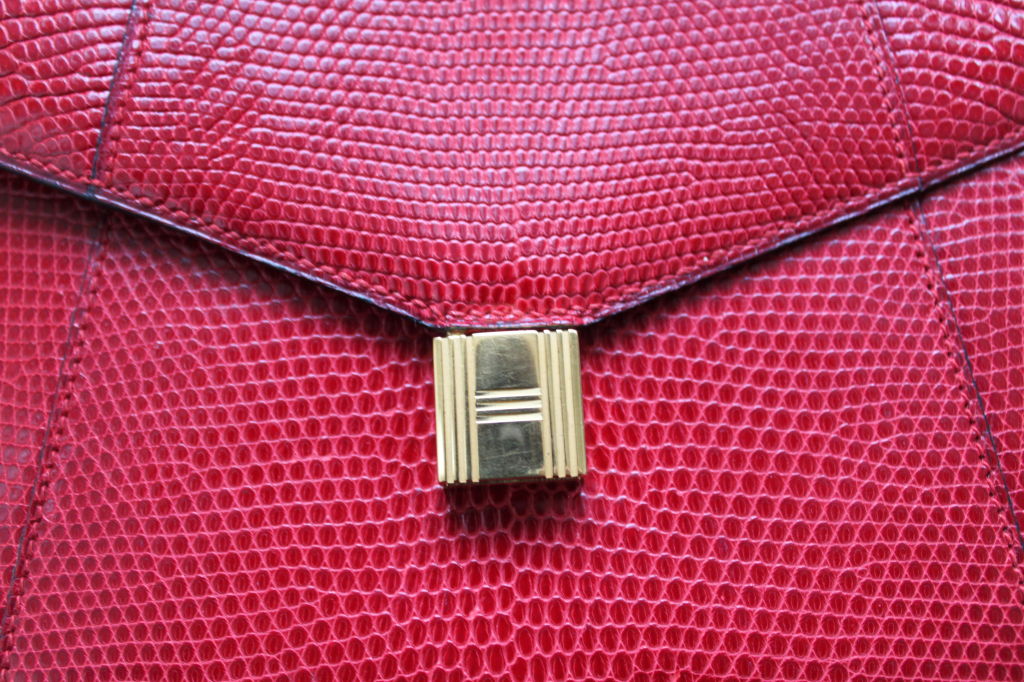 Gorgeous red lizard bag with gilt 'lock' hardware from Hermes. Bag measures 9