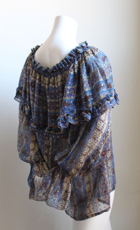 Beautiful semi sheer metallic silk peasant blouse with elasticized neckline that can be worn or or off the shoulders from Yves Saint Laurent dating to the late 1970's. Fits many sizes due to the loose cut. Made in France. Excellent condition.