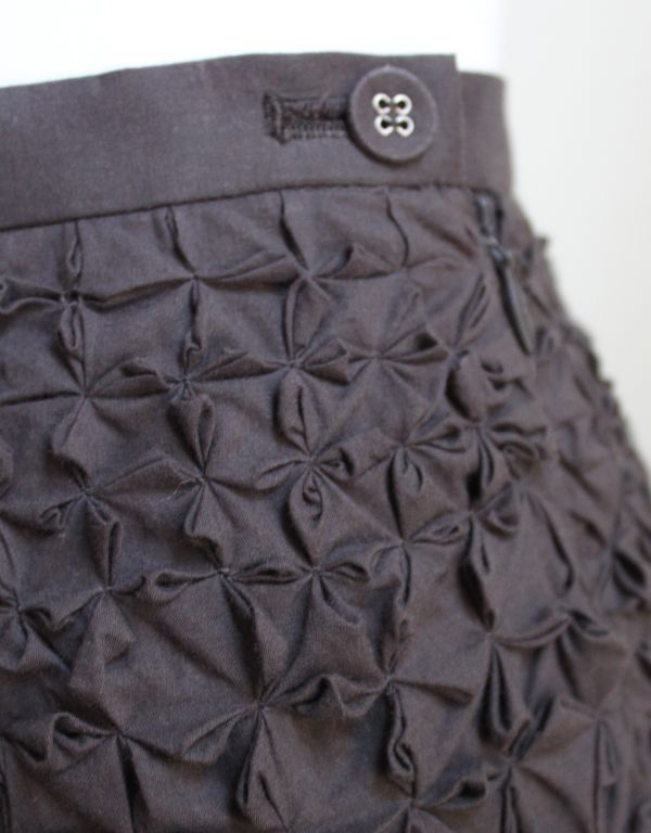 Charcoal cotton origami skirt from Issey Miyake dating to the 1990's. Zips up side and secures with a covered button. 28