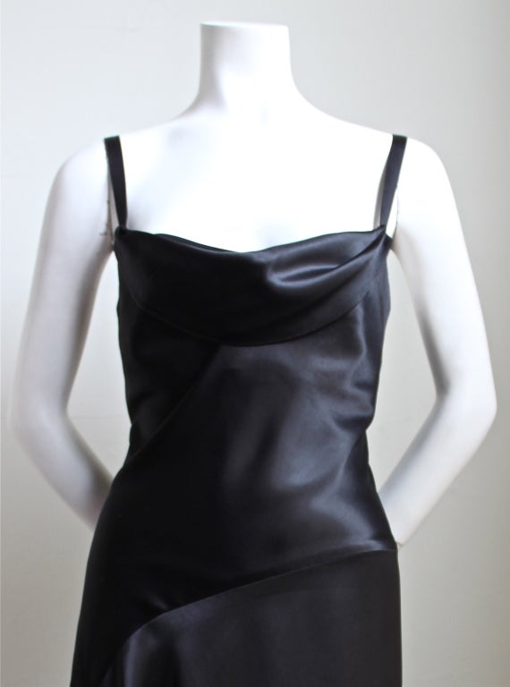 Beautiful jet black satin dress with draped neckline and asymmetrical hemline from Christian Lacroix dating to the late 1980's. Labeled a French size 40. Dress measures approximately: bust: 34
