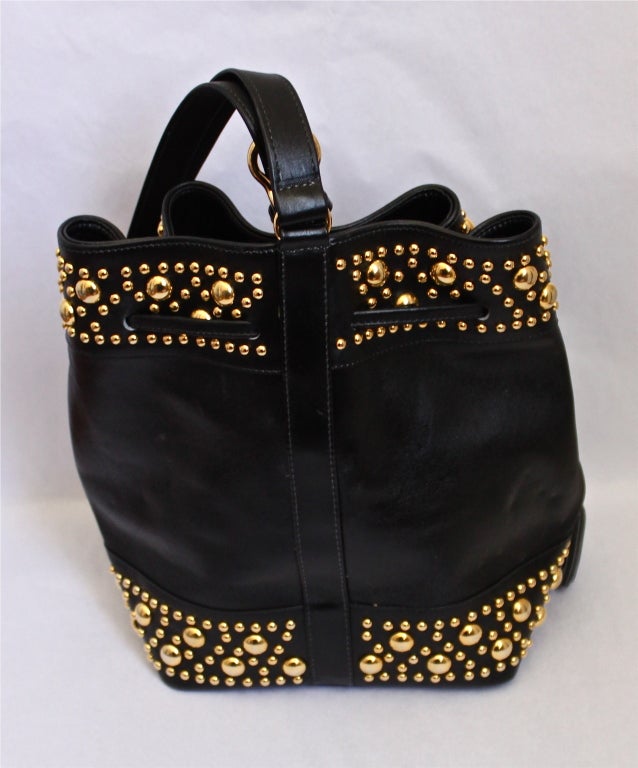 Jet black butter soft lambskin leather bucket bag with shinny gold studs from SepCoueur Paris. Bag measures about 10