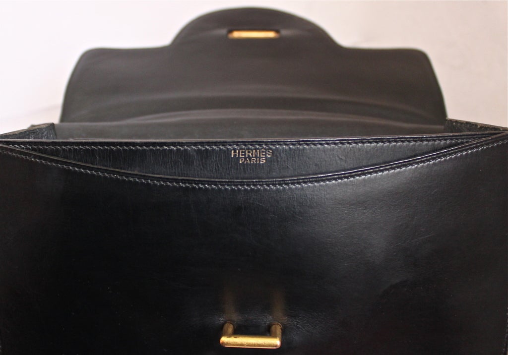 Classic jet black box leather bag with gilt hardware from Hermes dating to the 1970's. 23 cm size. Bag measures 9