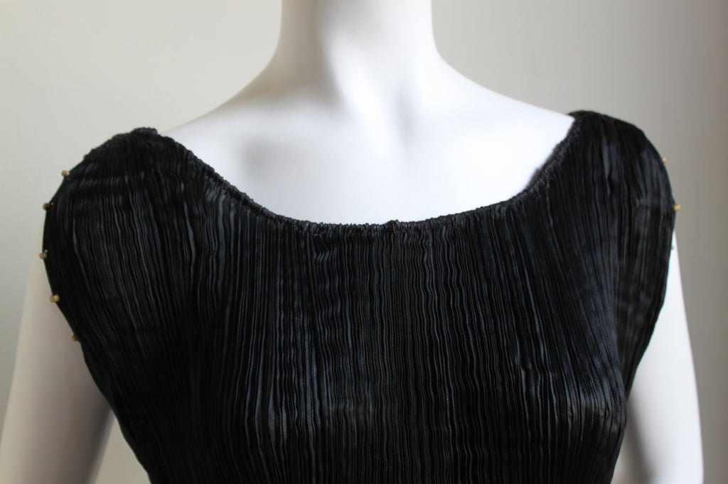 Phenomenal jet black pleated silk 'Delphos' gown with Venetian striped glass beads and stamped gold silk belt from Mariano Fortuny dating to the 1920's. Adjustable drawstring at neckline. Fits a variety of sizes due to the pleated construction.