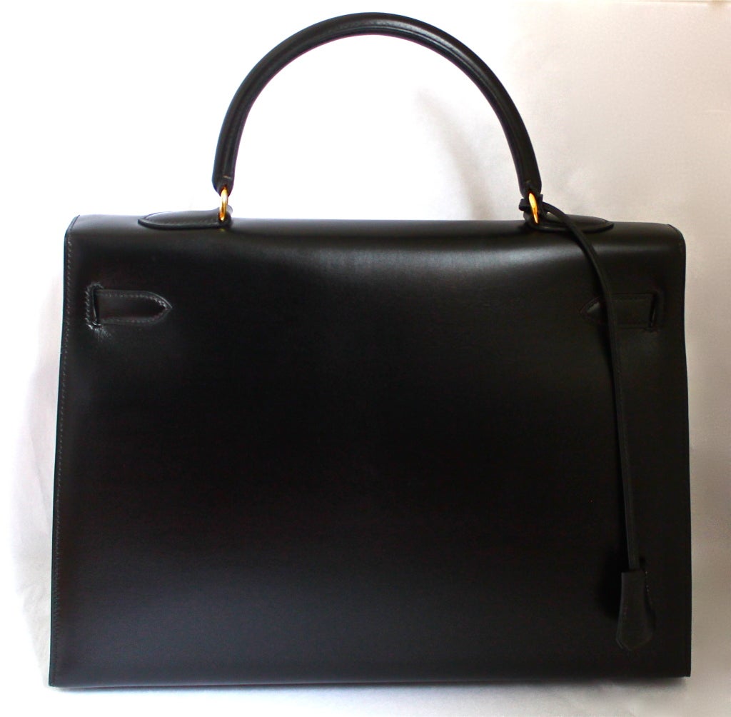 Classic jet black box leather 'Kelly' rigid model bag from Hermes dating to 1994. 35cm size. includes clochette, lock, keys, shoulder strap and original dust bag. Made in France. Excellent condition (looks very new ). More pictures are available