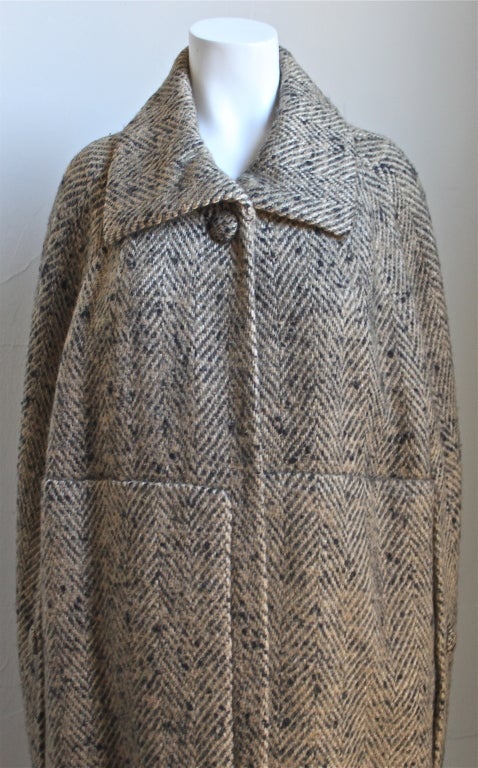Very rare haute couture wood tweed cape from Cristobel Balenciaga dating to the early 1960's. Numbered beneath Balenciaga label. Fully lined in silk. Single button closure at neck.  Buttons at arm openings. Made in France. Very good condition.