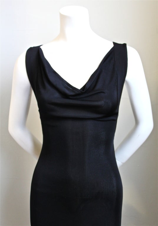 Dramatic jet black floor length knit gown with cross back designed by Alexander McQueen ca. 2005. Labeled a size small. Slips on over the head. Made in Italy. New with tags.